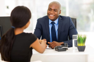 successful african american businessman handshaking with client in office