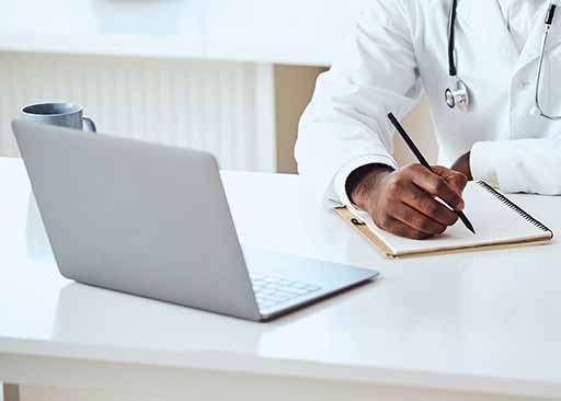 health information manager sitting at desk taking notes