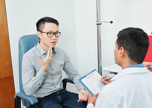 doctor using active listening skills with asian male patient