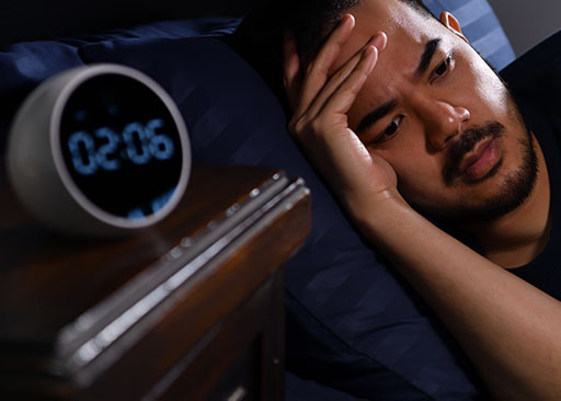 asian man awake at night wanting to fall asleep faster