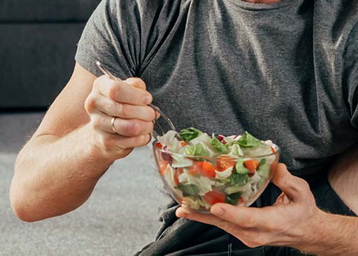 weißer mann, der salat isst, der den stoffwechselprozess startet