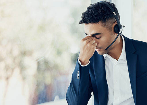 callcenter medewerker met hoofdpijn veroorzaakt door stress