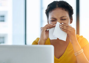 lady sneezing into tissue due to Immunodeficiency of immune system
