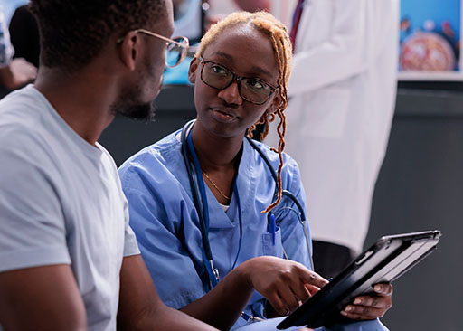 afroamerikanischer Patient und Krankenschwester diskutieren Ergebnisse von Bioresonanztests