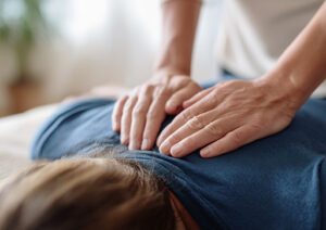 reiki trianing student gently placing hands on the back of a client