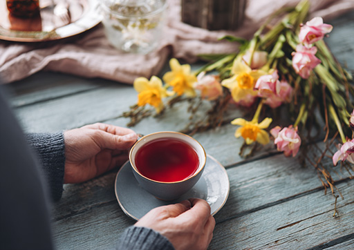 person sitting at a breakfast table drinking roselle tea