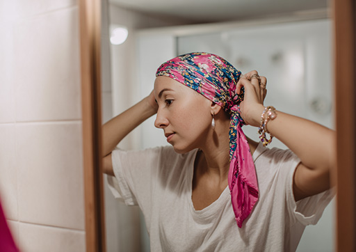 person standing in front of a mirror wearing a scarf on her head