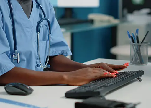 african american medical scribe typing on computer keyboard
