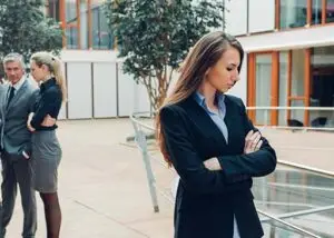 lady standing away from group expressing passive aggressive behavior
