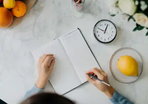 person writing in a food journal after receiving nutrition counseling