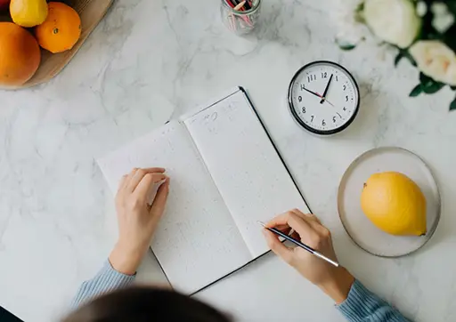 person writing in a food journal after receiving nutrition counseling