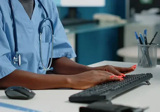 african american medical scribe typing on computer keyboard