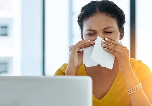 lady sneezing into tissue due to Immunodeficiency of immune system